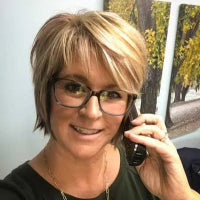 Sonya Durrence talking on the phone, smiling as she takes an order and listens to feedback from a satisfied customer